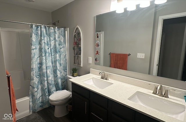 bathroom featuring double vanity, toilet, shower / bath combo, and a sink