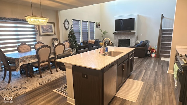 kitchen with dark wood-type flooring, open floor plan, dishwasher, a fireplace, and a sink