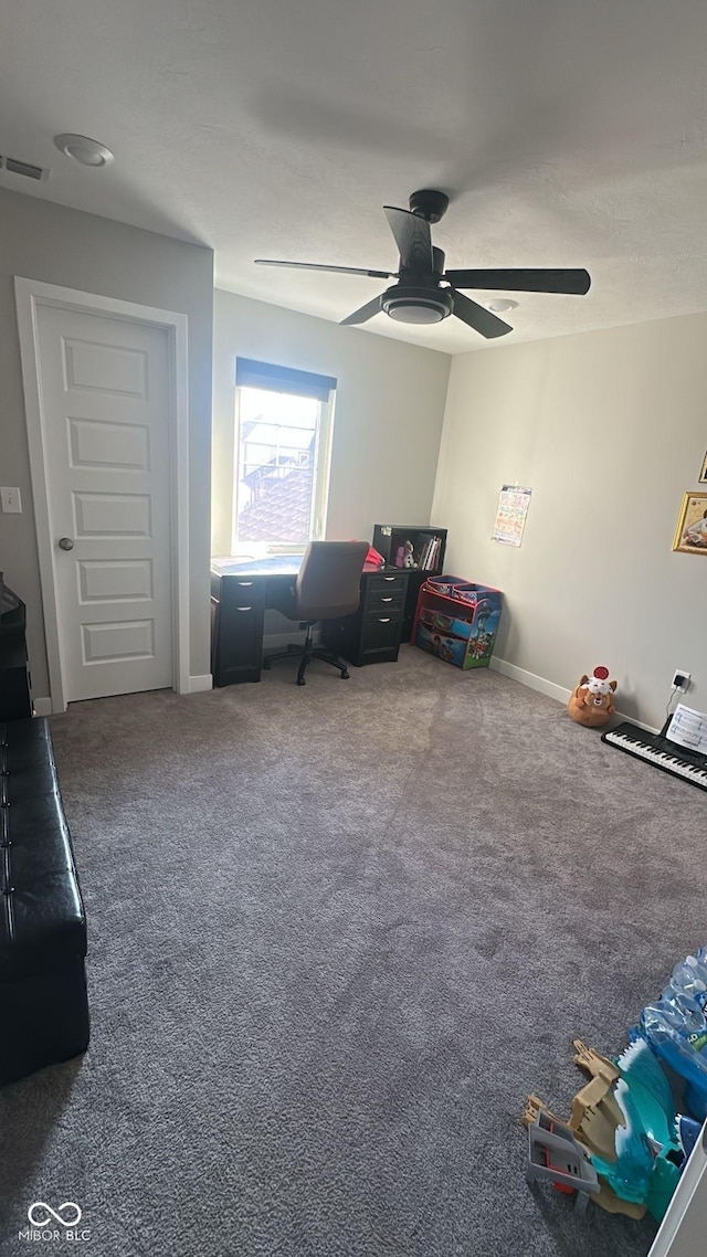 interior space featuring baseboards, carpet flooring, a ceiling fan, and visible vents