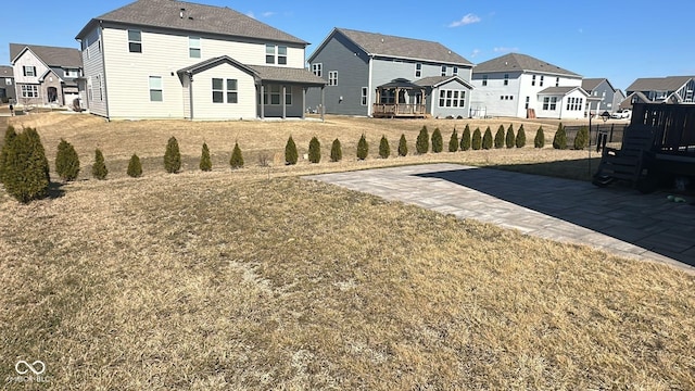 back of house featuring a yard and a residential view