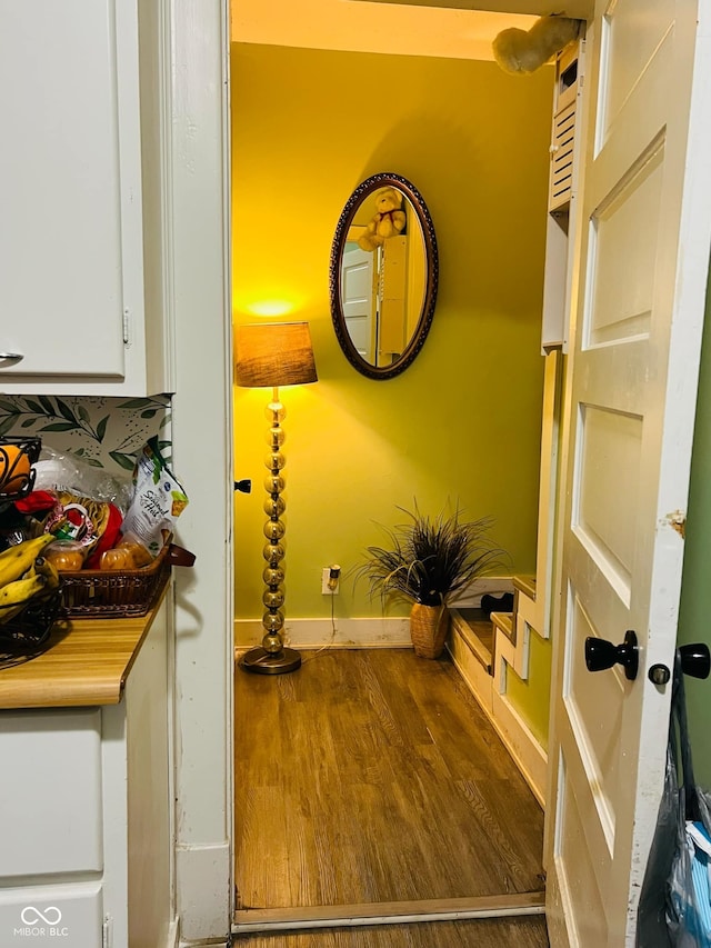 hallway with wood finished floors and baseboards