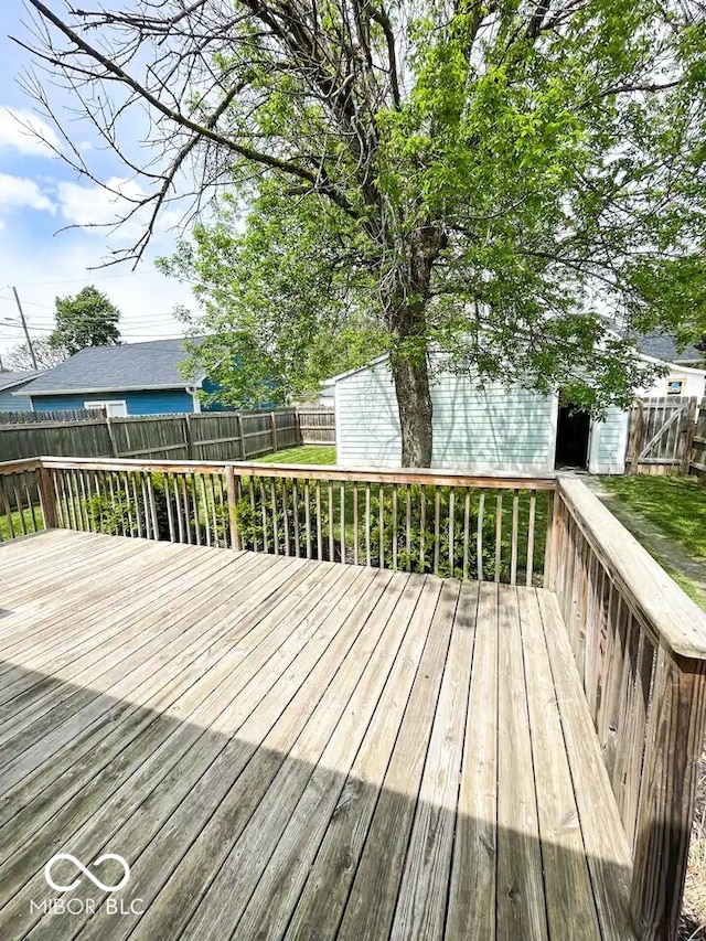 wooden deck with a fenced backyard