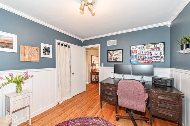 office area with visible vents, wainscoting, crown molding, and wood finished floors