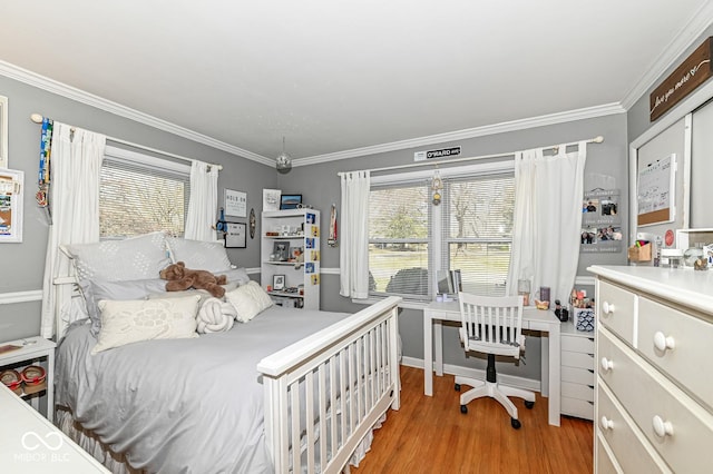 bedroom featuring multiple windows, light wood-style floors, and ornamental molding