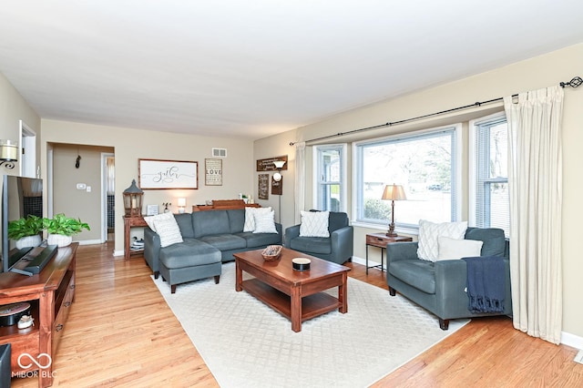 living area with visible vents, baseboards, and light wood finished floors