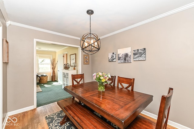 dining space featuring ornamental molding, baseboards, an inviting chandelier, and wood finished floors