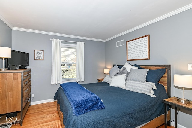 bedroom with visible vents, light wood-style flooring, crown molding, and baseboards