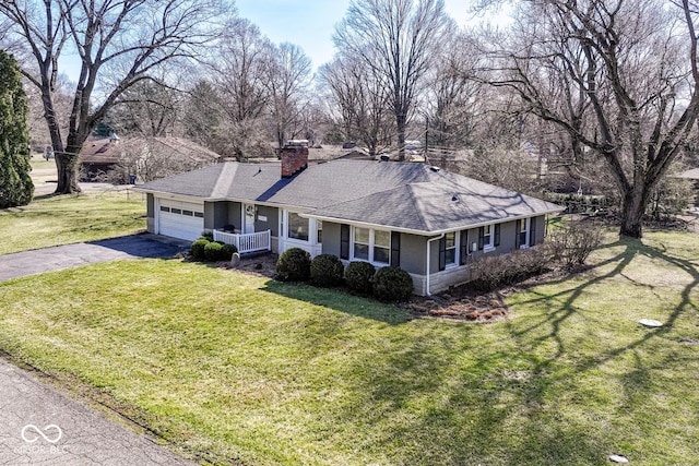 ranch-style home with a front lawn, aphalt driveway, roof with shingles, a chimney, and an attached garage