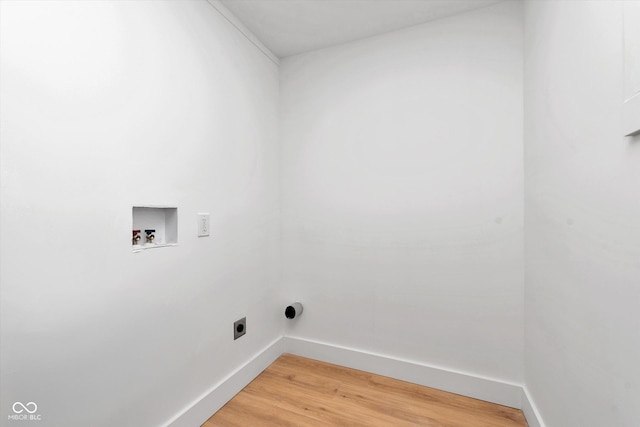 clothes washing area featuring hookup for a washing machine, electric dryer hookup, light wood-type flooring, laundry area, and baseboards