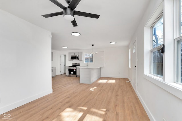 unfurnished living room with light wood finished floors, ceiling fan, and baseboards