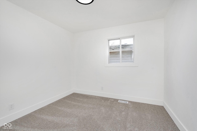 carpeted spare room featuring visible vents and baseboards