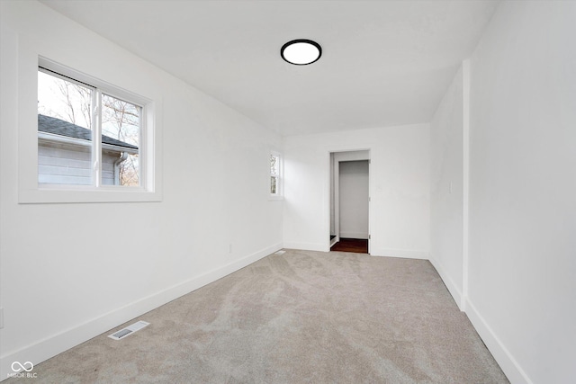 carpeted empty room with baseboards and visible vents