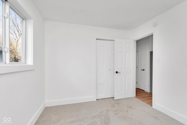 unfurnished bedroom with carpet flooring, baseboards, and multiple windows