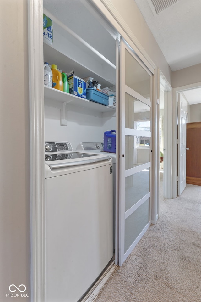 washroom featuring laundry area, visible vents, carpet floors, and washer and clothes dryer