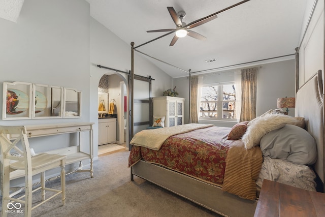 bedroom with carpet, visible vents, arched walkways, vaulted ceiling, and a barn door