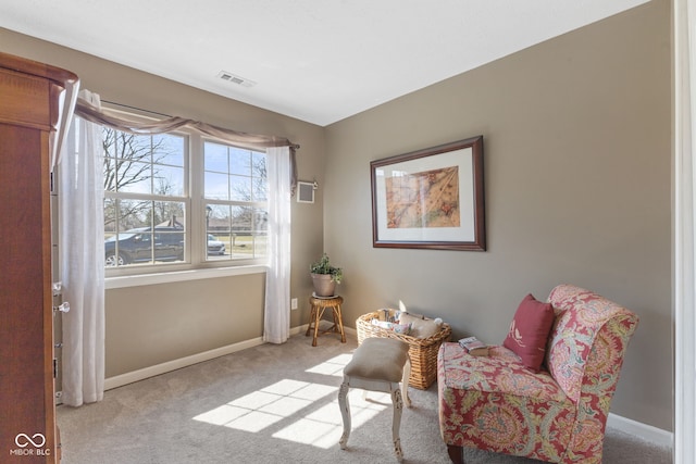 living area with visible vents, baseboards, and carpet