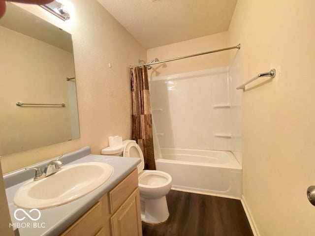 bathroom featuring toilet, shower / tub combo with curtain, wood finished floors, and vanity