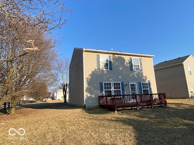 rear view of property featuring a deck and a yard