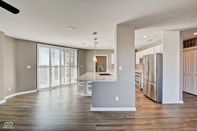 kitchen with dark wood-style floors, white cabinets, appliances with stainless steel finishes, and a sink