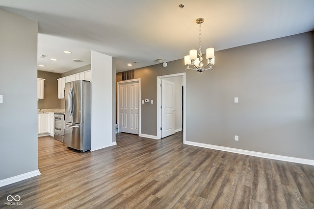 kitchen featuring white cabinetry, dark wood-type flooring, baseboards, and freestanding refrigerator