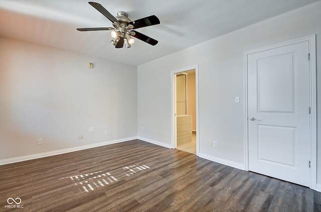 unfurnished bedroom featuring a ceiling fan, dark wood-style floors, baseboards, and connected bathroom