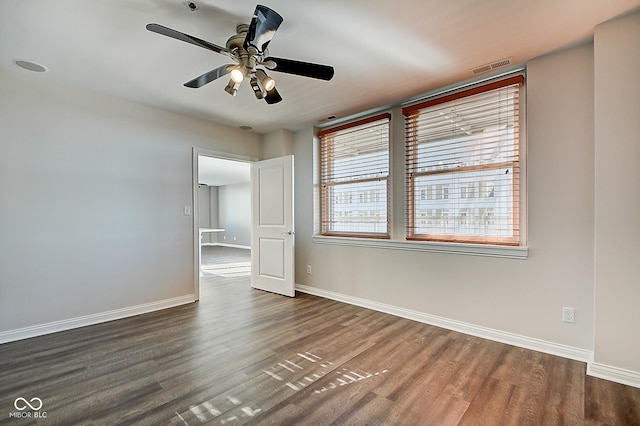 unfurnished bedroom with ceiling fan, visible vents, baseboards, and wood finished floors