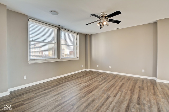 spare room featuring visible vents, baseboards, and wood finished floors