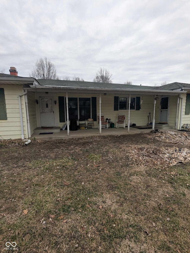 rear view of house featuring a yard and a patio