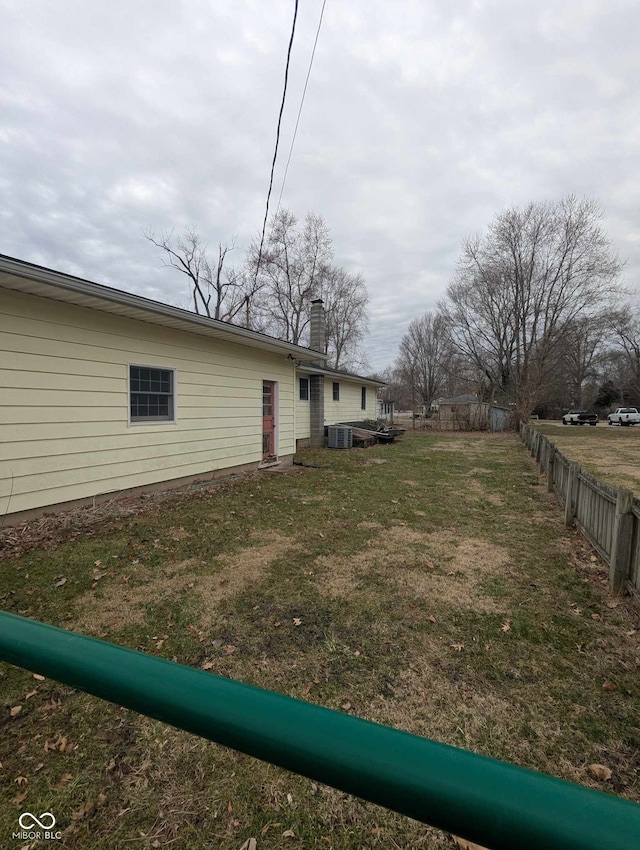 view of yard featuring fence and cooling unit