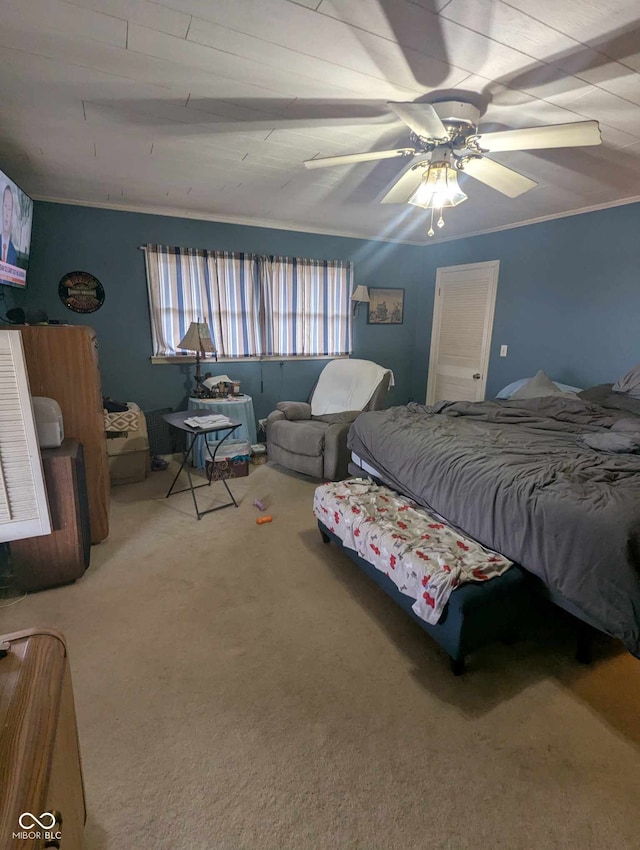 carpeted bedroom with ornamental molding and a ceiling fan