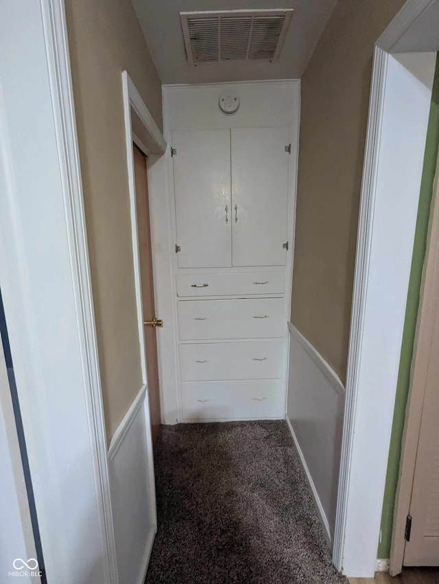 hallway featuring carpet floors and visible vents