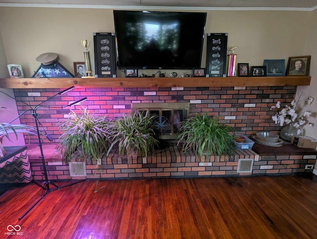 interior space featuring visible vents, crown molding, and wood finished floors