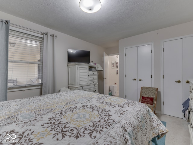 bedroom featuring a textured ceiling and two closets