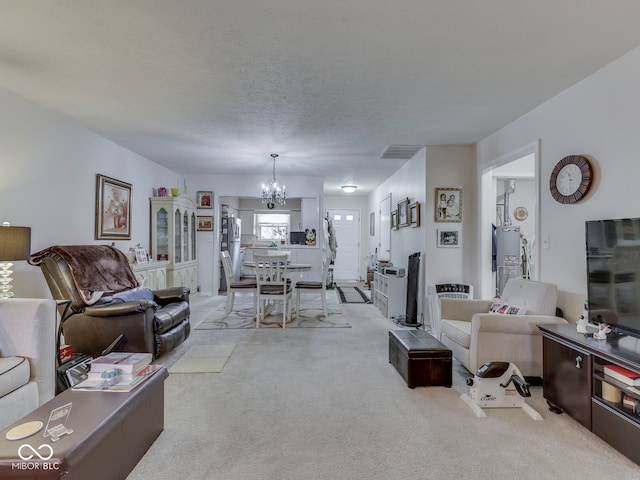 living room with a textured ceiling, a chandelier, and light carpet