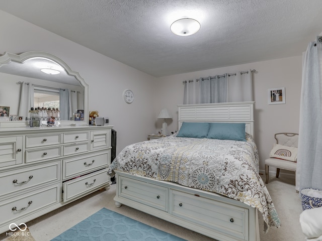 bedroom with a textured ceiling and light carpet