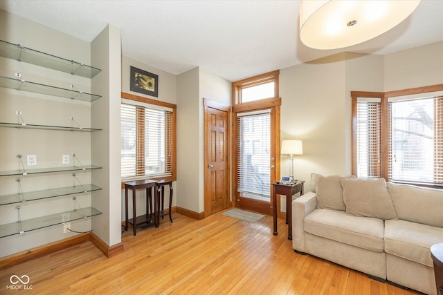 living area with a wealth of natural light, light wood finished floors, and baseboards