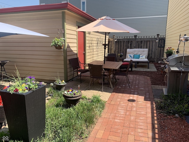 view of patio / terrace featuring an outdoor living space, fence, and a grill