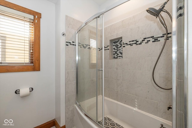 full bathroom with bath / shower combo with glass door