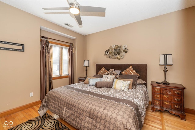 bedroom with visible vents, light wood-style flooring, baseboards, and ceiling fan