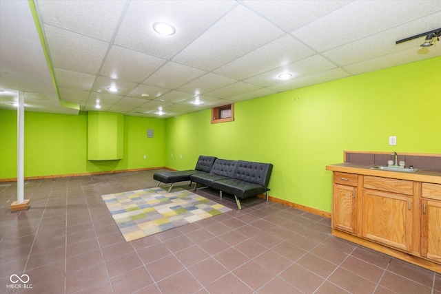 interior space with a sink, baseboards, a paneled ceiling, and recessed lighting