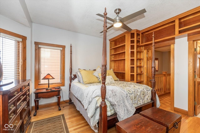 bedroom with baseboards, ceiling fan, a textured ceiling, and light wood-style floors