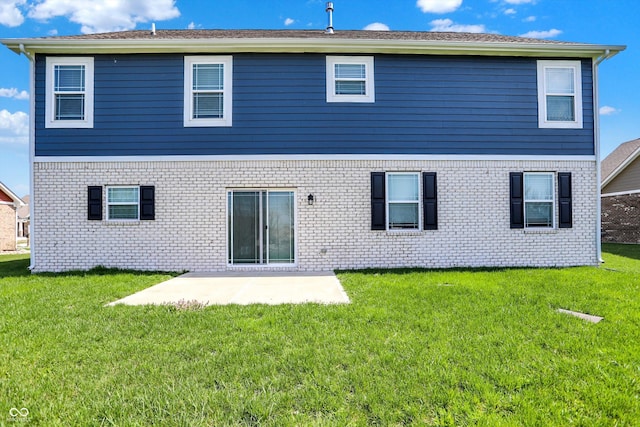 rear view of house with brick siding, a patio area, and a lawn