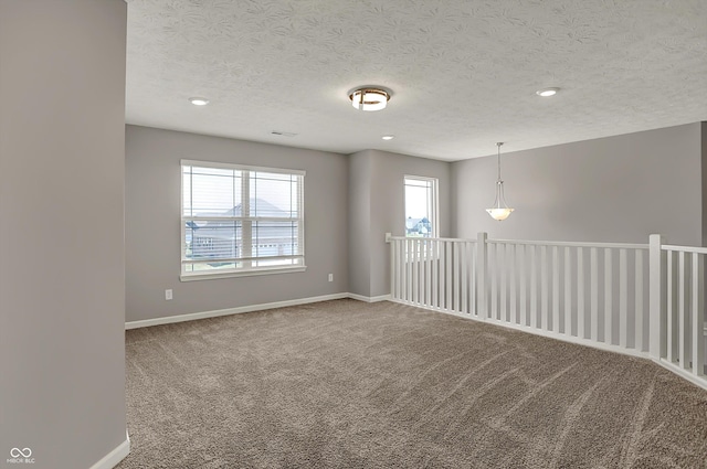 unfurnished room with a textured ceiling, baseboards, carpet, and recessed lighting