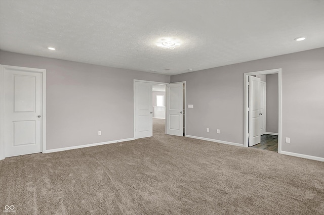 unfurnished bedroom featuring a textured ceiling, recessed lighting, baseboards, and carpet floors