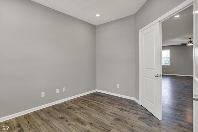 spare room featuring dark wood-style flooring, baseboards, a ceiling fan, and recessed lighting