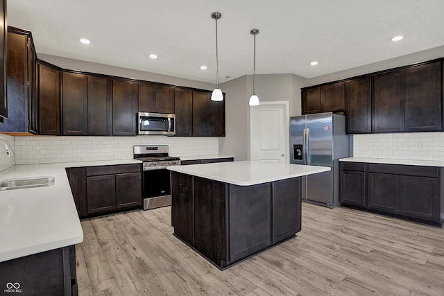 kitchen with stainless steel appliances, a sink, dark brown cabinets, and decorative backsplash