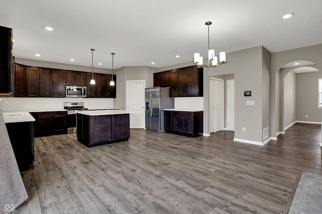 kitchen with arched walkways, visible vents, light countertops, and appliances with stainless steel finishes