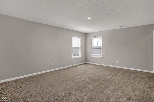 carpeted spare room featuring a textured ceiling, baseboards, and recessed lighting