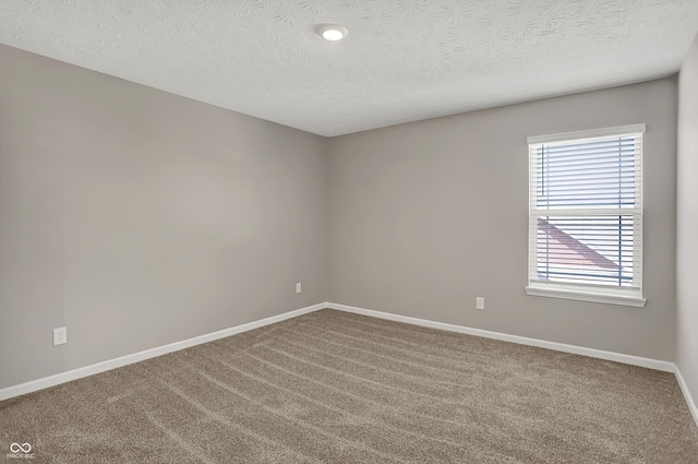 carpeted empty room with a textured ceiling and baseboards