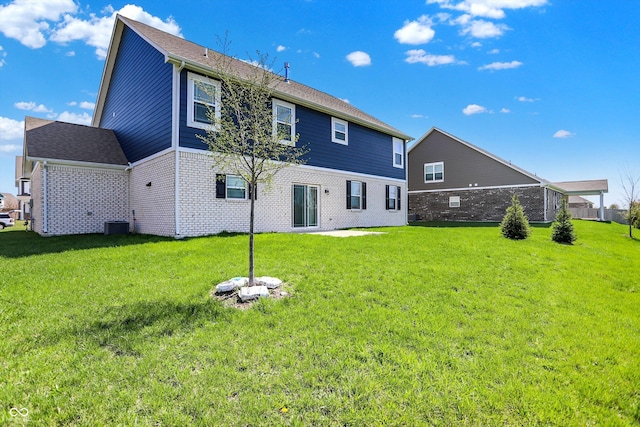 back of house with a yard and brick siding